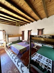 um quarto com 2 beliches e um tecto de madeira em willkasunco Casa Hospedaje em Amaicha del Valle