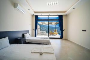 a bedroom with two beds and a large window at Villa Huzurlu in Kaş +37 photos
