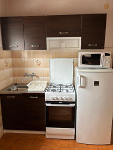 a kitchen with a white stove and a microwave at Csobánc Ház in Siófok