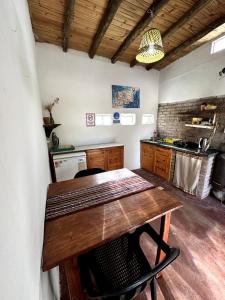uma cozinha com uma mesa de madeira num quarto em willkasunco Casa Hospedaje em Amaicha del Valle