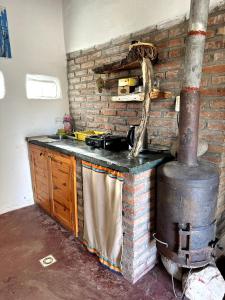 uma cozinha com um fogão e uma parede de tijolos em willkasunco Casa Hospedaje em Amaicha del Valle