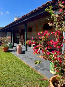 a house with pink flowers in front of it at Pousada Recanto Janbor in Olímpia +6 photos