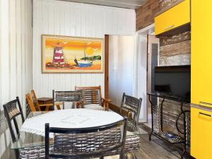 a dining room with a table and chairs and a television at Contêiner Exclusivo - Praia da Gamboa - GAR001 in Gamboa +20 photos