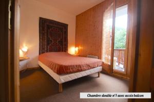 a bedroom with a bed and a large window at Chalet Du Regain - Chalet 4 pièces 8 personnes 3 exposé Sud-Ouest MAE-8244 in Valloire