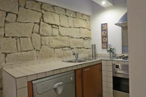 uma cozinha com um lavatrio e uma parede de pedra em Casa do O - Alojamento Local na Tbua mais 37 fotografias