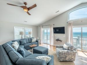sala de estar con sofá azul y ventilador de techo en Eagles Landing, en Surf City