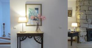 uma sala de estar com uma mesa com flores em Casa do O - Alojamento Local na Tbua