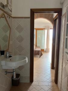 Un baño con lavabo y una habitación con cama. en Villetta Zuccale III Natura e Vista Mozzafiato sul Mare, en Capoliveri 25 fotos más