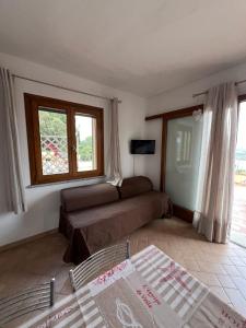 Una sala de estar con un sofá y una ventana. en Villetta Zuccale III Natura e Vista Mozzafiato sul Mare, en Capoliveri