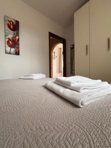 1 dormitorio con 2 toallas blancas en una cama en Villetta Zuccale III Natura e Vista Mozzafiato sul Mare, en Capoliveri