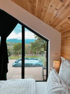 a bedroom with a view of a hot tub outside at Zenit Chalet Sohodol-Bran in Sohodol