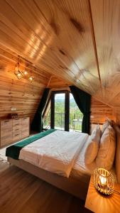 a bedroom with a large bed in a wooden ceiling at Zenit Chalet Sohodol-Bran in Sohodol