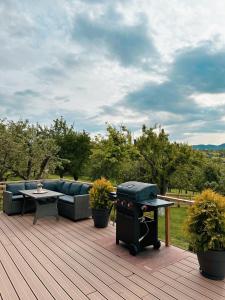 a patio with a couch and a grill on a deck at Zenit Chalet Sohodol-Bran in Sohodol