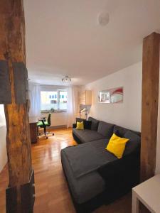 a living room with a black couch and yellow pillows at Luckenberg in Fulda
