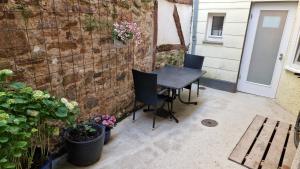 a patio with a table and chairs next to a brick wall at Luckenberg in Fulda