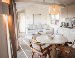 a living room with a table and a couch at Waterfront tiny home with spacious garden in Vinkeveen