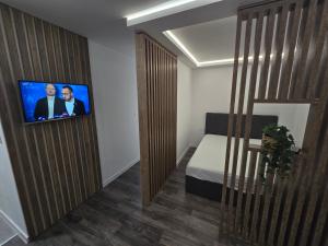 a room with a bed and a tv on a wall at Excellente apartman in Ðurđenovac
