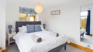 a bedroom with a large white bed with two pillows at East View, a stunning home from home in St Helens, sleeps 6. in Saint Helens