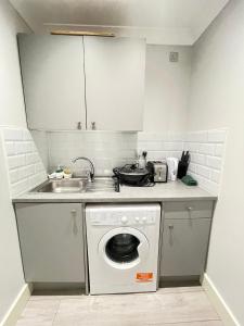 kuchnia z pralką i zlewem w obiekcie Green Lanes w Londynie