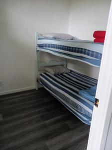 two bunk beds in a room with wooden floors at Maison Marcotte in Saint-Michel