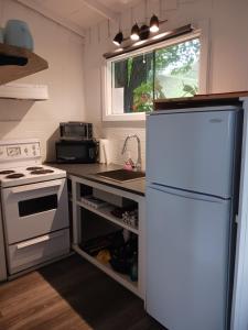 a kitchen with a white refrigerator and a sink at Maison Marcotte in Saint-Michel