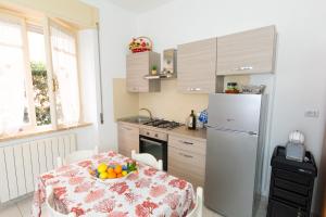 a kitchen with a table with a bowl of fruit on it at Relax al mare, appartamento Gelsomino in San Vincenzo +7 photos