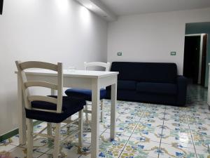 Zimmer mit einem Tisch, einem Stuhl und einem Sofa in der Unterkunft Dimora Maradona in Neapel