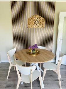 a dining room with a wooden table and chairs at Fördeliebe in Heikendorf
