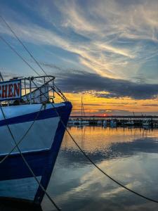 a boat is docked at a marina with a sunset at Fördeliebe in Heikendorf