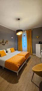 a bedroom with two beds with orange sheets and a window at B&B Casa Davide in Bergamo +18 photos