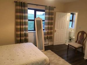 a bedroom with a bed and a window and a chair at Entire home in Belmullet in Belmullet
