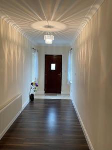an empty hallway with a door and a cat sitting on the floor at Entire home in Belmullet in Belmullet