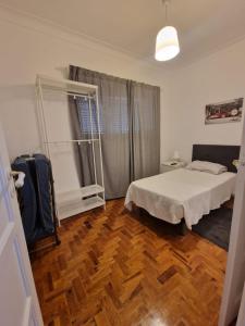 a bedroom with a white bed and a wooden floor at Boa Noite Casa de Hospedes in Lisbon