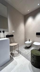 bagno con lavandino, servizi igienici e tavolo di Berht - Appartamenti al centro di Catania a Catania