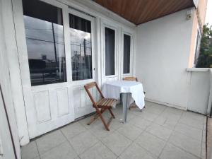 een tafel en stoelen op een veranda met een tafel en een raam bij Pousada Jardins Campista in Macaé
