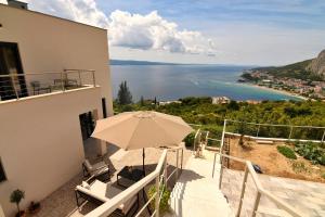 a balcony with an umbrella and a view of the ocean at Casa Miele in Omiš