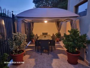 a table and chairs under an umbrella on a patio at Studio Aurora Blue in Eforie Sud