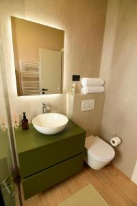 a bathroom with a sink and a toilet and a mirror at Casa Miele in Omiš +18 photos