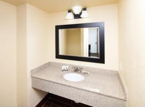 a bathroom with a sink and a mirror at GuestPlace Inn & Suites in Redding