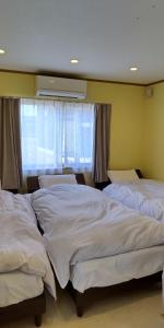 two beds in a bedroom with a window at Ume House - Vacation STAY 95412v in Tokamachi