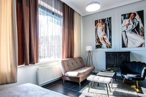 a living room with a couch and a chair at Apartament Pasaż in Giżycko