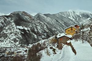 a cabin in the snow with mountains in the background at Abba Ordino Babot Hotel in Ordino