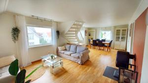 een woonkamer met een bank en een tafel bij Central modern Lyse Fjord apartment in Stavanger