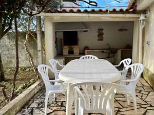 a white table and white chairs on a patio at Lisbonne et sa région en famille ou entre amis! in Alcoitão