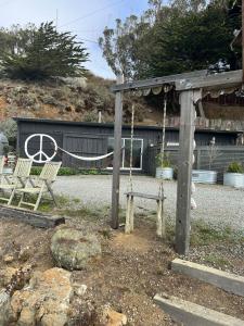 Carriage House Waterfront On Tomales Bay With Dock في Marshall: ملعب به كرسيين ومرجيح