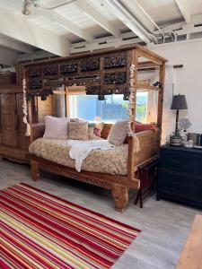 a bedroom with a canopy bed and a rug at Carriage House Waterfront On Tomales Bay With Dock in Marshall