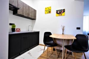 cocina con sillas negras y mesa de madera en Lagom Comfort Home, en Ancona 4 fotos más