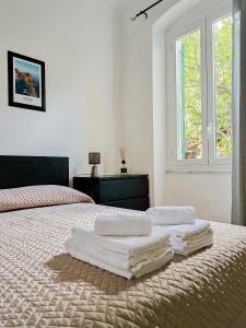 a white bedroom with a bed with towels on it at Narissara apartment in La Spezia