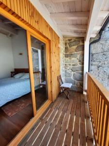 um quarto com uma varanda com uma cama e uma janela em CASA DO EIRÓ em Lobios
