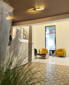 a lobby with two yellow chairs in a building at RIG Colonial Experience in Santo Domingo